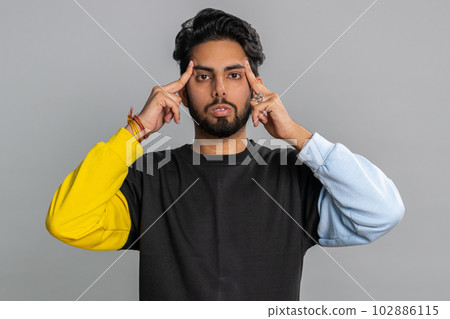 Indian man rubbing temples to cure headache problem, suffering from tension and migaine stress pain Indian man rubbing temples to cure headache problem, suffering from tension and migaine stress pain 102886115