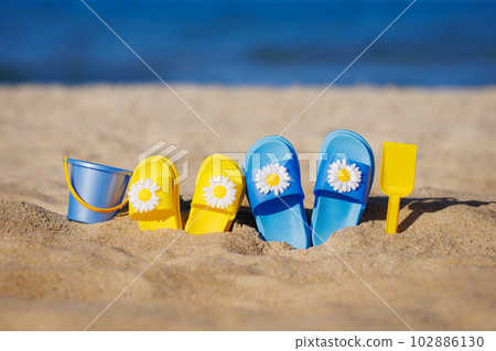 Childrens flip-flops on the beach. Summer vacation concept Childrens flip-flops on the beach. Summer vacation concept 102886130