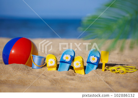 Kids flip-flops, beach ball and snorkel on the sand. Summer vacation concept Kids flip-flops, beach ball and snorkel on the sand. Summer vacation concept 102886132