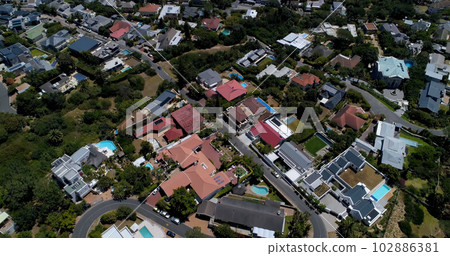 General view of city with street, houses and green part with trees General view of city with street, houses and green part with trees 102886381