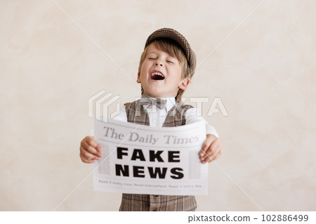 Newsboy shouting against grunge wall background. Boy selling fake news Newsboy shouting against grunge wall background. Boy selling fake news 102886499