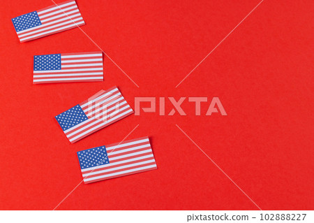 High angle view of four flags of united states of america with copy space on red background 102888227