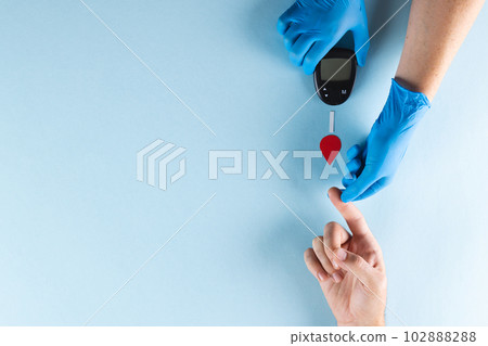 Hands of gloved doctor with glucometer taking blood sugar reading from caucasian woman, copy space 102888288