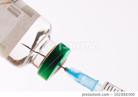 Syringe filling from vial of clear liquid such as insulin, on white background with copy space 102888300