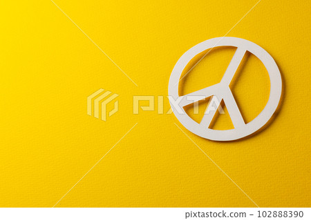 High angle view of white peace sign with copy space on yellow background 102888390