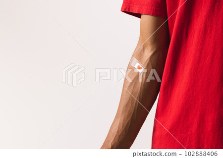 Midsection of biracial man with heart sticking plaster on arm, on white background with copy space Midsection of biracial man with heart sticking plaster on arm, on white background with copy space 102888406