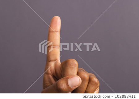 Hand of biracial man with outstretched forefinger, on grey background Hand of biracial man with outstretched forefinger, on grey background 102888411