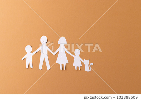 White paper cut out of family with two children and ca and copy space on brown background White paper cut out of family with two children and ca and copy space on brown background 102888609