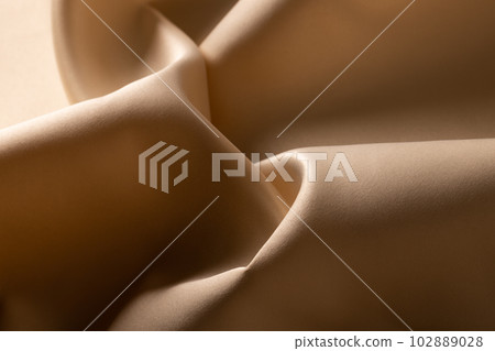 Close up of plain beige satin fabric with folds, copy space Close up of plain beige satin fabric with folds, copy space 102889028