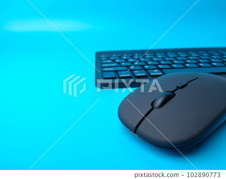Malaysia,30 April 2022: Black Bluetooth wireless keyboard and wireless mouse on a blue background. Malaysia,30 April 2022: Black Bluetooth wireless keyboard and wireless mouse on a blue background. 102890773