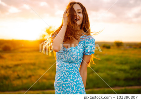 Young woman sits on a plaid with a book. Summer picnic in nature. Healthy food. 102890807