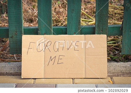Forgive me word handwritten on cardboard against the background of a fence. Please forgive me. Forgive me word handwritten on cardboard against the background of a fence. Please forgive me. 102892029