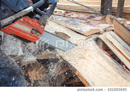 Sawmill. Lumberjack cutting a tree with a chainsaw at a sawmill. Sawmill. Lumberjack cutting a tree with a chainsaw at a sawmill. 102893695