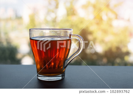 A cup of tea is at the window. Morning tea. Tea party on the background of the window 102893762