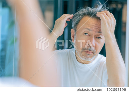 A middle-aged man who cares about his hair A middle-aged man who cares about his hair 102895196