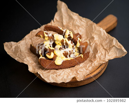 Cheese, croutons - an appetizer for beer on parchment from above on a black background 102895982