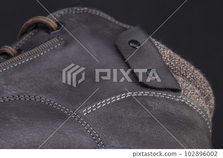 Part of a leather boot close-up. A fragment of the texture of leather shoes. 102896002