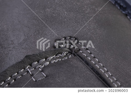 Part of a leather boot close-up. A fragment of the texture of leather shoes. Part of a leather boot close-up. A fragment of the texture of leather shoes. 102896003