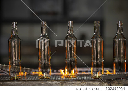 Glassworks. Glass industry. Glass bottle on conveyor on fire Glassworks. Glass industry. Glass bottle on conveyor on fire 102896034