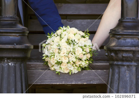 Wedding bouquet in the hands of the groom and the bride Wedding bouquet in the hands of the groom and the bride 102896071