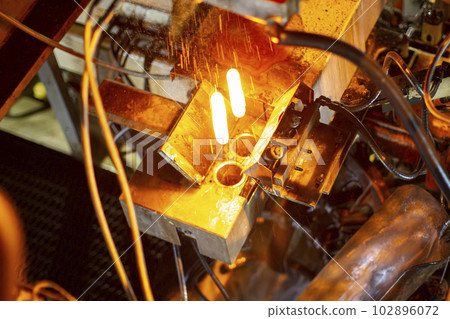 Glassworks. Glass industry. Burning blanks of glass bottles in an industrial stove 102896072