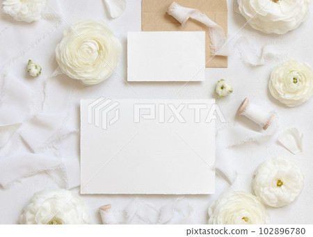 Blank cards near cream roses and white silk ribbons top view, wedding mockup Blank cards near cream roses and white silk ribbons top view, wedding mockup 102896780