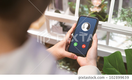 Woman holding mobile phone with incoming call from unknown caller. scammer or stranger, Hoax person with fake identity, Prank caller, anonymous, smartphone, Fraud or phishing concept, Woman holding mobile phone with incoming call from unknown caller. scammer or stranger, Hoax person with fake identity, Prank caller, anonymous, smartphone, Fraud or phishing concept, 102899639