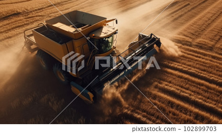 Ingathering. Sowing. A bird's-eye view of a combine harvester driving through a golden field at sunset. The Golden Hour. Dust rises from the back of the combine. Generated by AI 102899703