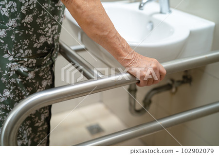 Asian elderly old lady woman patient use toilet bathroom handle security in nursing hospital, healthy strong medical concept. 102902079