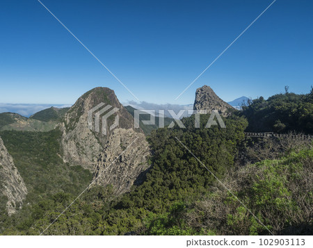 Scenic view from the Mirador del Bailadero with volcanic rock formations Los Roques and island Tenerife and Volcano Pico de Teide. Garajonay National Park on La Gomera, Canary Islands, Spain, Europe. 102903113