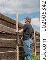 An adult man is engaged in carpentry work at a house construction site 102905342