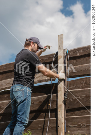 An adult man is engaged in carpentry work at a house construction site An adult man is engaged in carpentry work at a house construction site 102905344