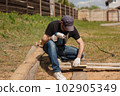 Man builds sections of fence around his yard out of planks 102905349