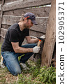 Man builds sections of fence around his yard out of planks 102905371