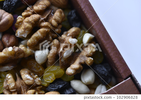 Assorted nuts in a box close-up. Delicious different nuts in a box. 102906828