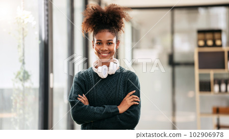 African american student woman in sweater wearing headphones aro African american student woman in sweater wearing headphones aro 102906978
