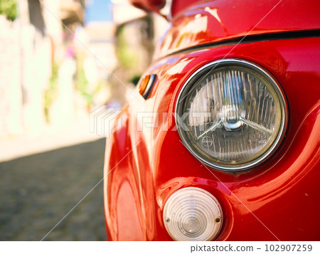 headlights of a red retro car close-up 102907259