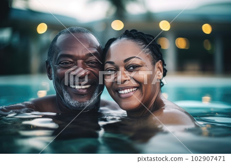 Mixed race middle age couple enjoying time in pool Mixed race middle age couple enjoying time in pool 102907471