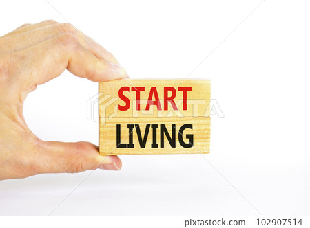 Start living symbol. Concept words Start living on beautiful wooden block. Beautiful white table white background. Businessman hand. Business and Start living concept. Copy space. 102907514