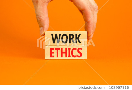 Work ethics symbol. Concept words Work ethics on beautiful wooden block. Beautiful orange table orange background. Businessman hand. Business and Work ethics concept. Copy space. Work ethics symbol. Concept words Work ethics on beautiful wooden block. Beautiful orange table orange background. Businessman hand. Business and Work ethics concept. Copy space. 102907516