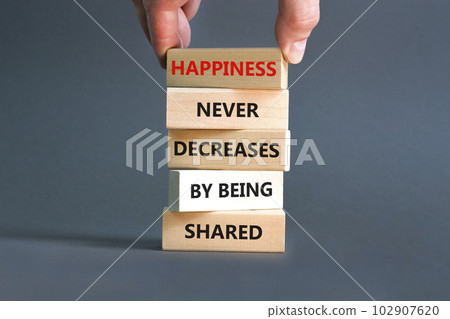 Happiness symbol. Concept words Happiness never decreases by being shared on wooden block. Businessman hand. Beautiful grey table grey background Motivational Happiness concept. Copy space. 102907620