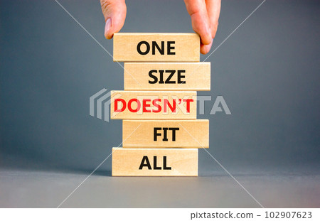 One size does not fit all symbol. Concept words One size does not fit all on wooden blocks. Businessman hand. Beautiful grey background. One size does not fit all business concept. Copy space. 102907623