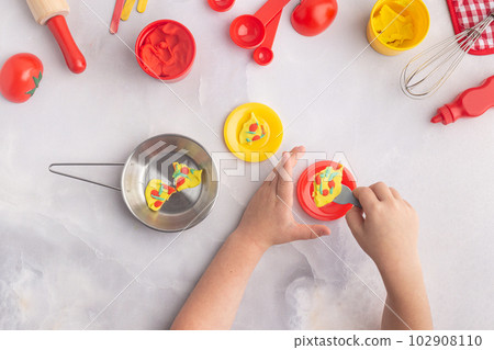 Boy's hands are making pizza with play dough. Kid's plasticine craft for art lesson. Boy's hands are making pizza with play dough. Kid's plasticine craft for art lesson. 102908110