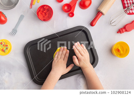 Boy's hands are making pizza with play dough. Kid's plasticine craft for art lesson. 102908124