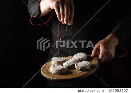 The chef adds salt to cutlets on a cutting board. Cooking meat patties for a burger. Free space for advertising 102908207