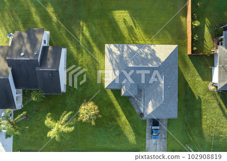 Aerial view of small town America suburban landscape with private homes between green palm trees in Florida quiet residential area 102908819
