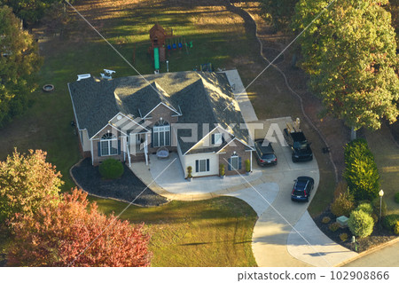 Aerial view of new family house between yellow trees in South Carolina suburban area in fall season. Real estate development in american suburbs 102908866