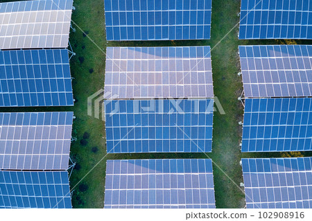 Aerial view of large sustainable electrical power plant with rows of solar photovoltaic panels for producing clean ecological electric energy. Renewable electricity with zero emission concept. Aerial view of large sustainable electrical power plant with rows of solar photovoltaic panels for producing clean ecological electric energy. Renewable electricity with zero emission concept. 102908916