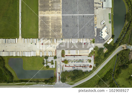 Aerial view of large commercial distribution center with many trucks unloading and uploading retail products for further shipment. Global economy concept 102908927