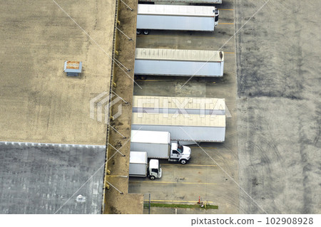 Aerial view of large commercial distribution center with many trucks unloading and uploading retail products for further shipment. Global economy concept 102908928